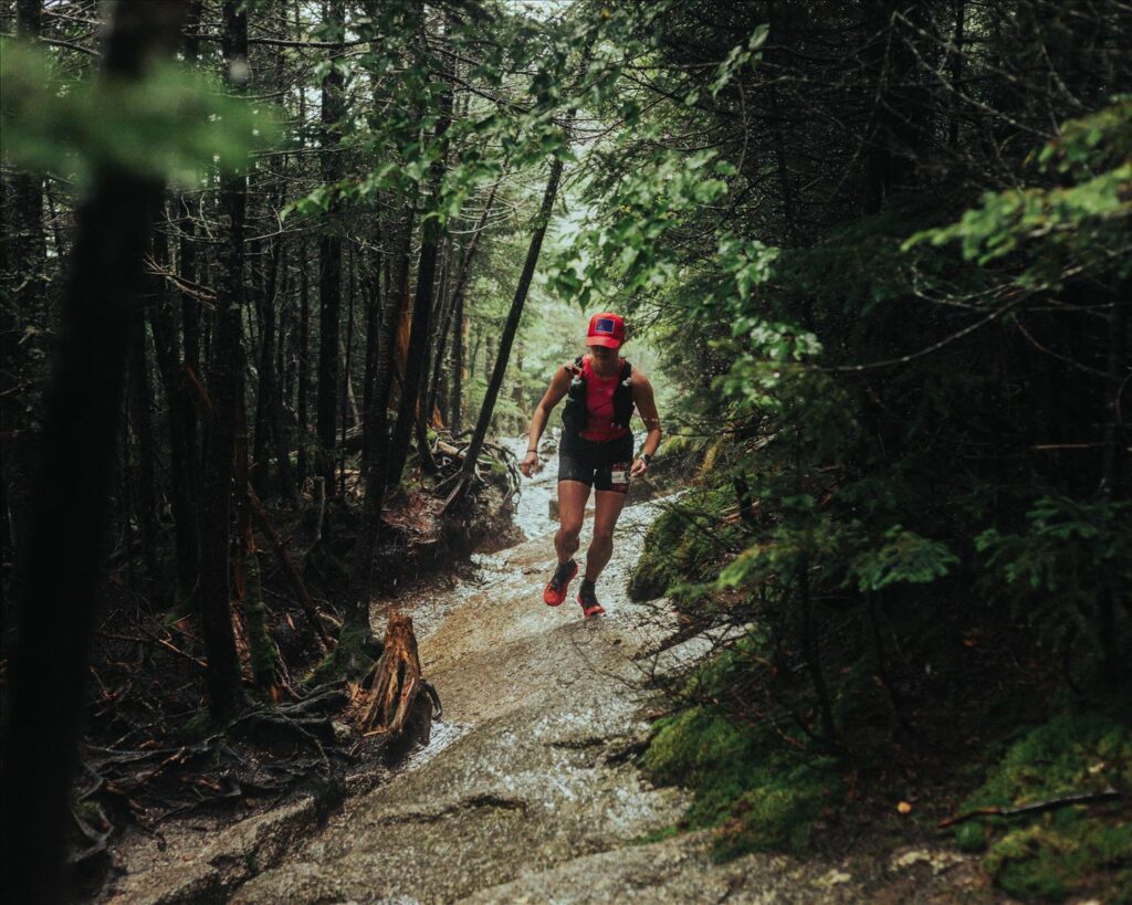 Trail runner runs up steep, rocky trail.